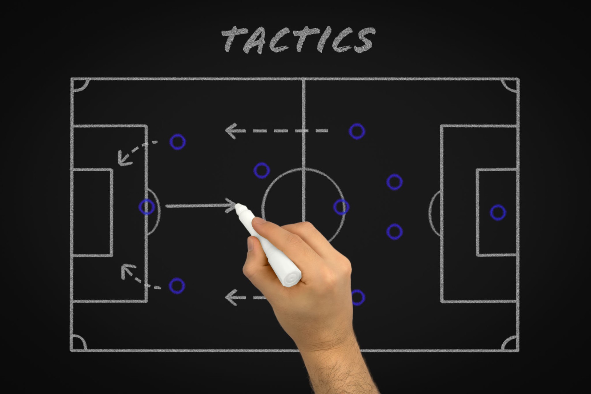 Hand of football coach explaining soccer match tactics on black chalk board